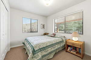 Carpeted bedroom featuring a closet and baseboards