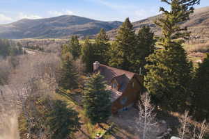 Aerial view of property and surrounding area with a mountainous background