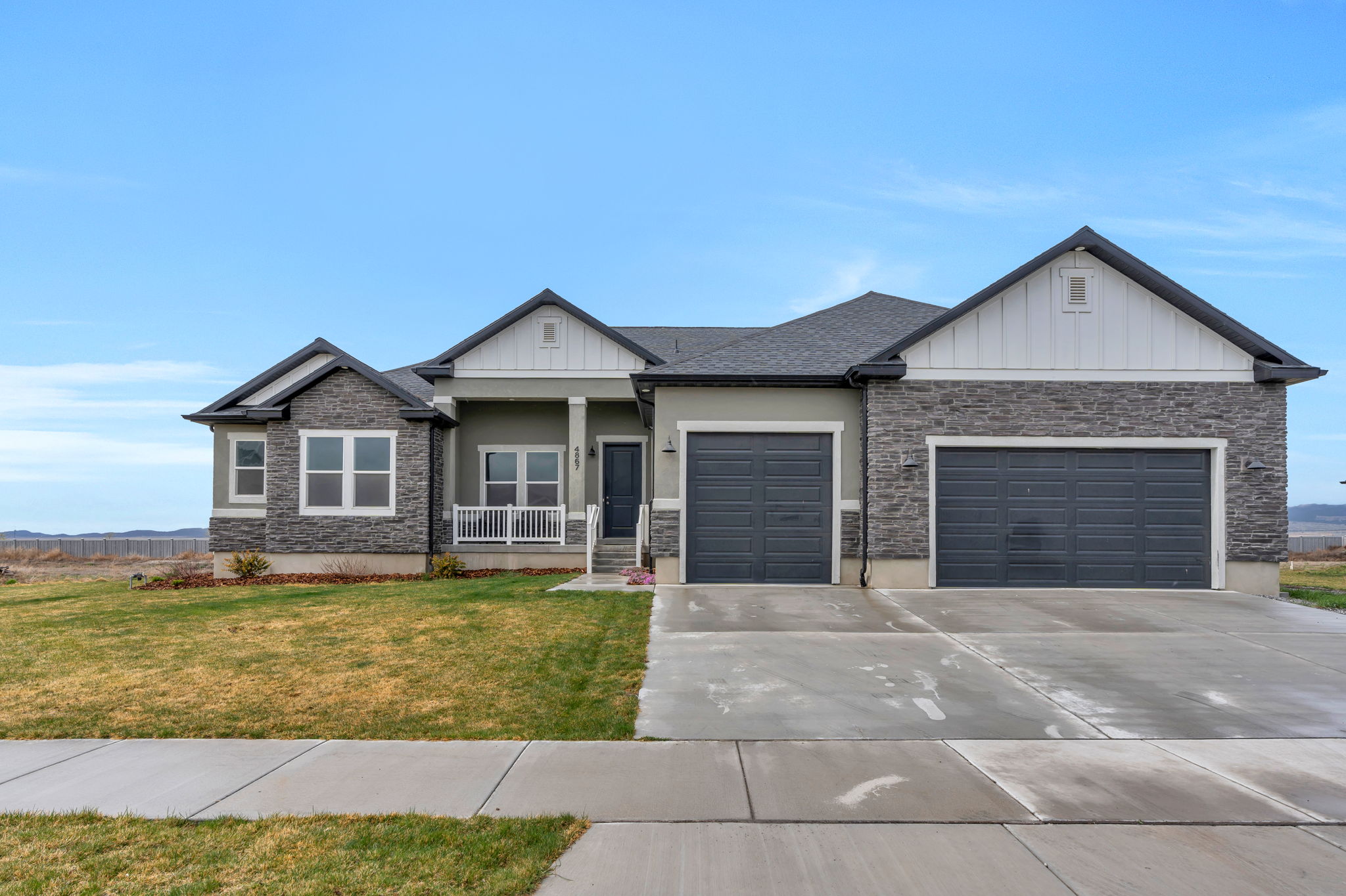 Craftsman inspired home featuring board and batten siding, stone siding, and a porch