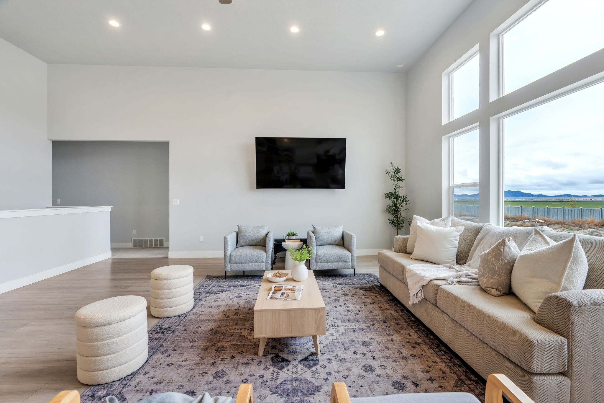 Living area featuring wood finished floors, recessed lighting, and a high ceiling