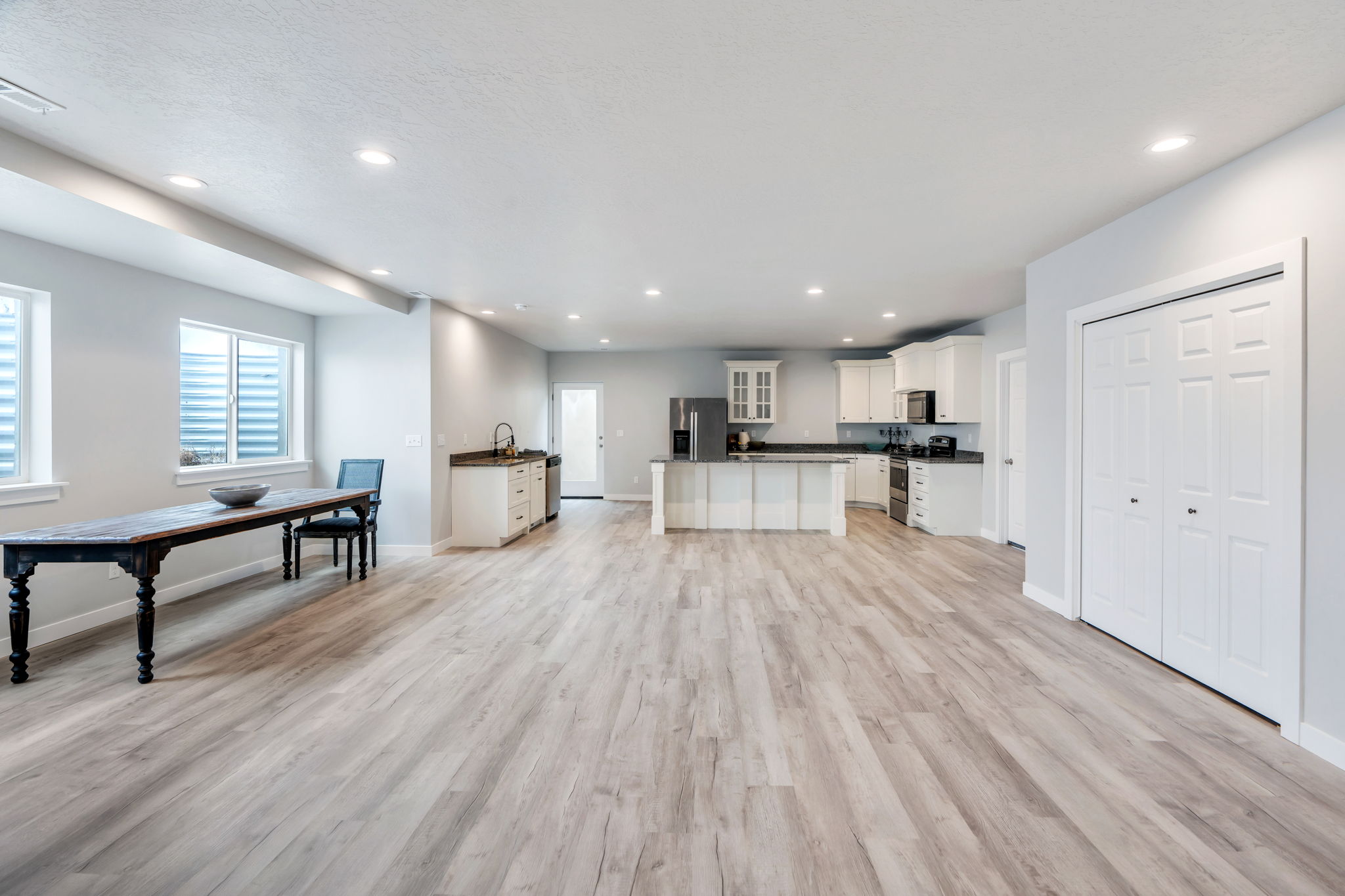 Kitchen featuring dark countertops, a kitchen island, white cabinets, and recessed lighting