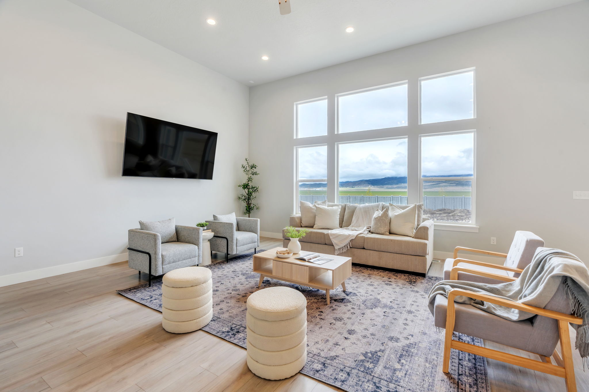 Living room with wood finished floors, a high ceiling, and recessed lighting