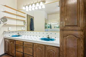 Bathroom featuring tasteful backsplash and double vanity