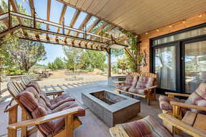 View of patio with a pergola and an outdoor living space with a fire pit