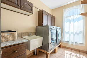 Laundry area featuring cabinet space, independent washer and dryer, and light tile patterned floors