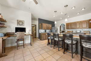 Kitchen with backsplash, open shelves, arched walkways, wood finish cabinets, and pendant lighting
