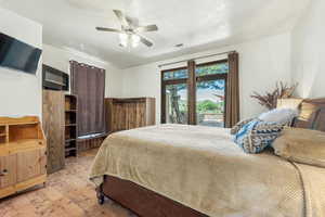 Bedroom featuring wood-type flooring, access to outside, ceiling fan, and a textured ceiling