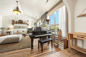 Living area with light wood-type flooring and vaulted ceiling