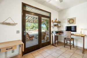 Doorway to outside with ceiling fan and tile patterned flooring