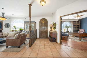 Foyer with plenty of natural light, a textured ceiling, ceiling fan, and light tile patterned floors