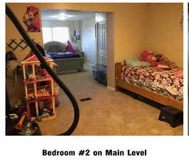 Bedroom featuring light carpet and baseboards