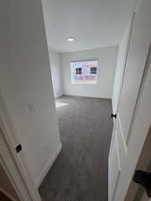 Spare room with dark colored carpet and baseboards