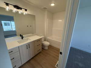 Bathroom featuring vanity, light wood finished floors, and shower / washtub combination