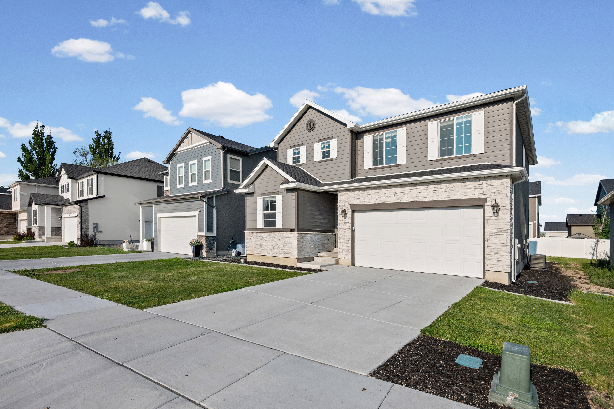 Contemporary home with stone facade accents and neutral siding