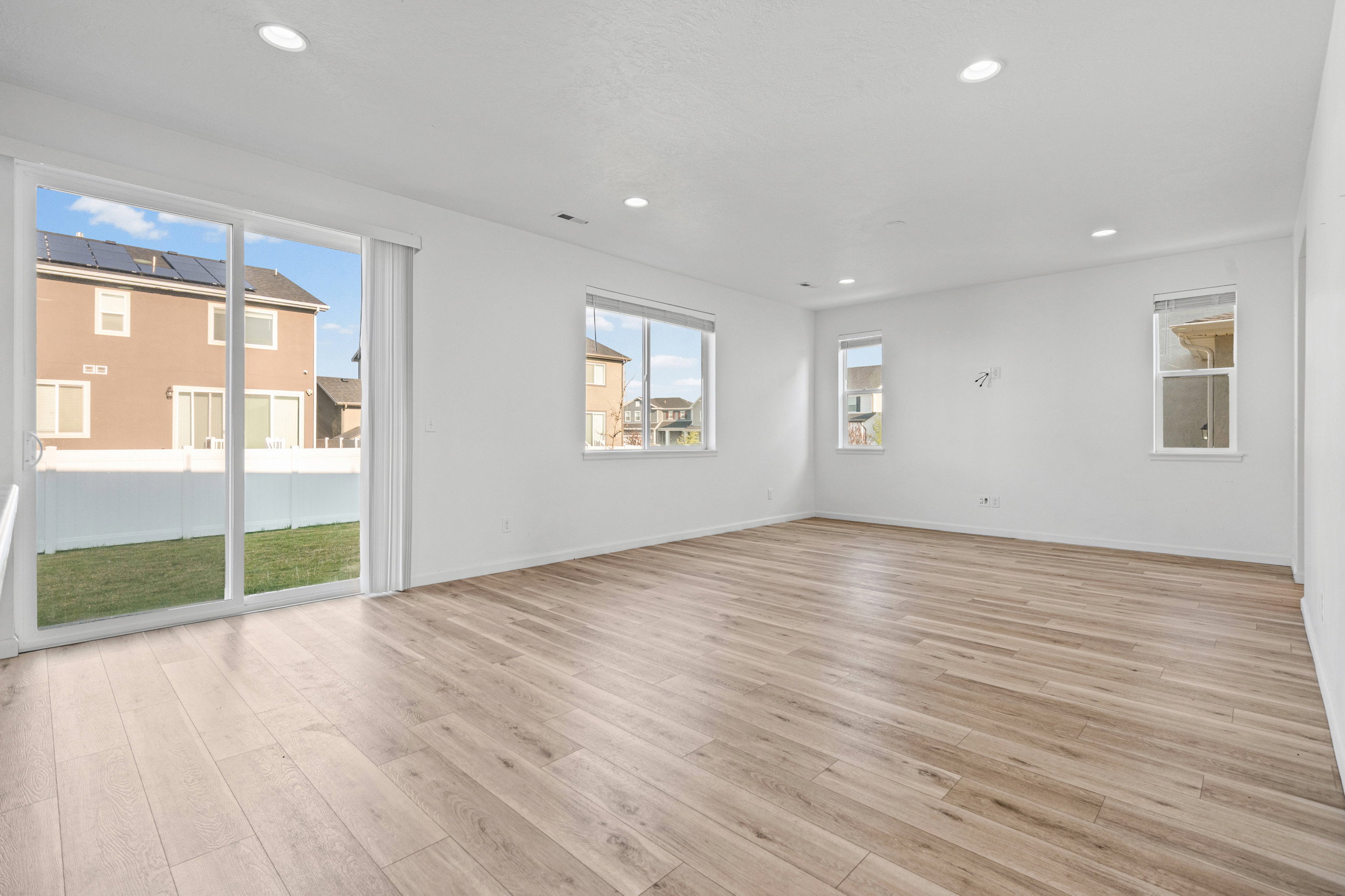 Spacious interior featuring wood-finish flooring, recessed lighting, and multiple windows