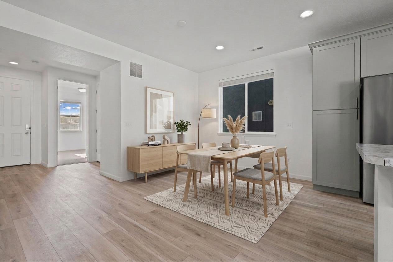 Open-concept dining area featuring wood-finish flooring, a contemporary window, recessed lighting, and a neutral color palette