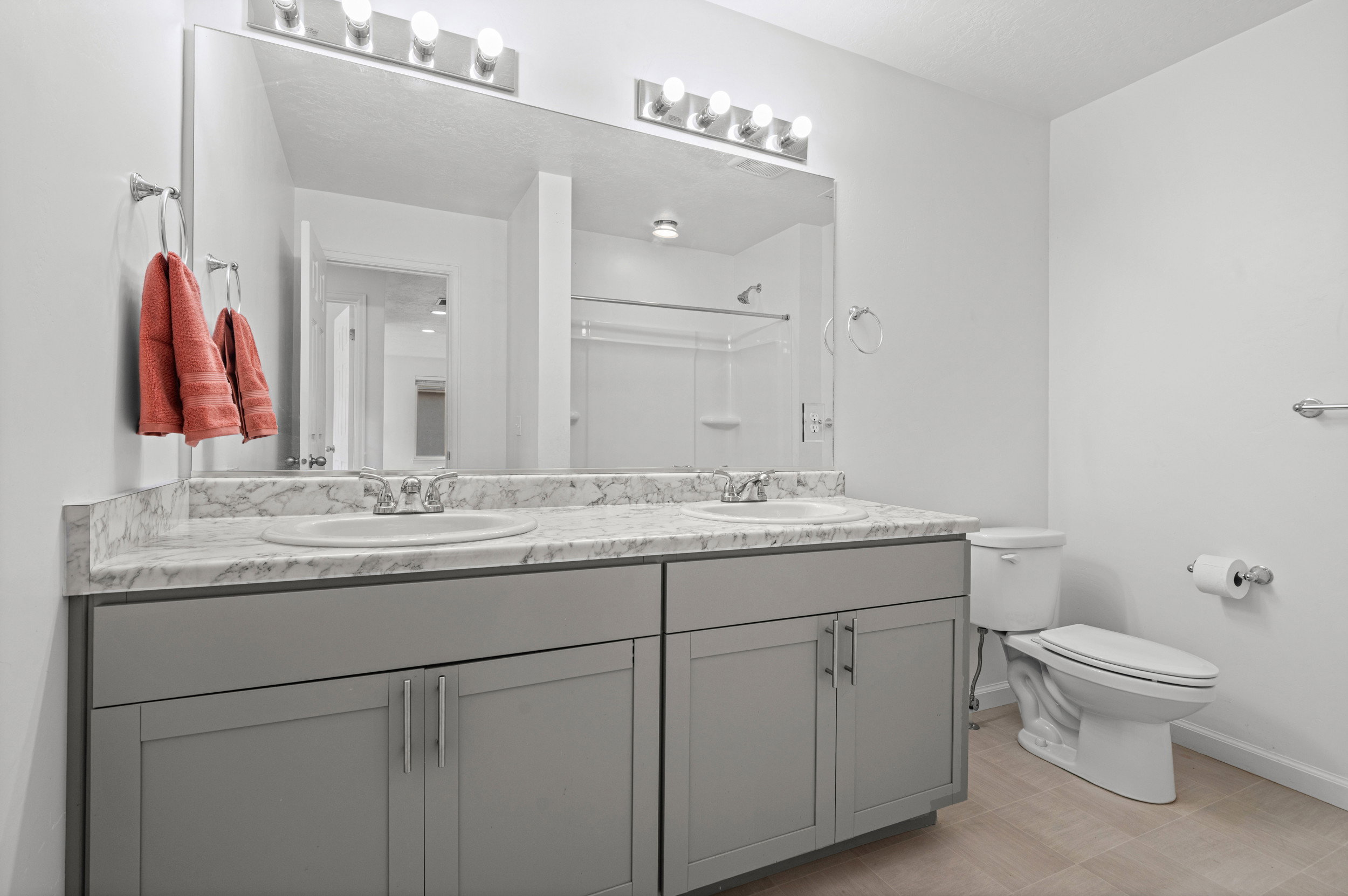 Double vanity with gray cabinetry, white countertops, and integrated sinks