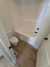 Bathroom with light wood-type flooring and  shower combination