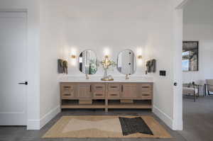 Bathroom with double vanity and baseboards