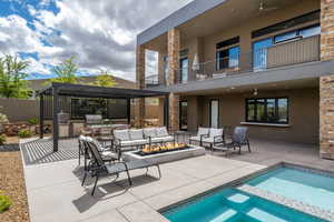Relaxing pool / spa with an outdoor kitchen and area to lounge, a patio, an outdoor fire pit, and a balcony