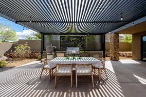 Fenced backyard with an outdoor kitchen / dining area, a pergola, and a patio
