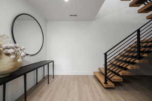 Staircase featuring wood finished floors and baseboards