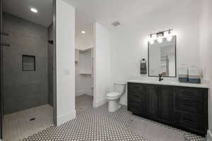 Full bathroom with vanity, a shower stall, a walk in closet, and recessed lighting