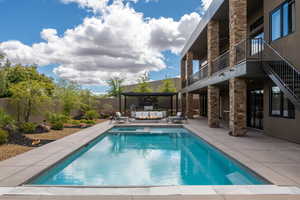 Relaxing pool / spa with a patio, a balcony, outdoor furniture, and a fenced backyard