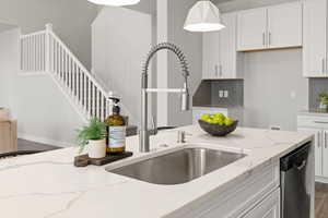 Kitchen featuring waterfall quartz island, gas countertop range, range hood, pendant lighting, soft close drawers and cabinets