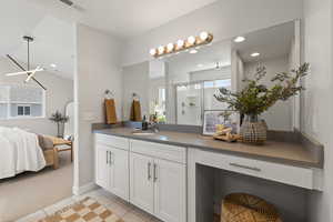 Master bath with quartz countertop, walk-in shower, and tile floors