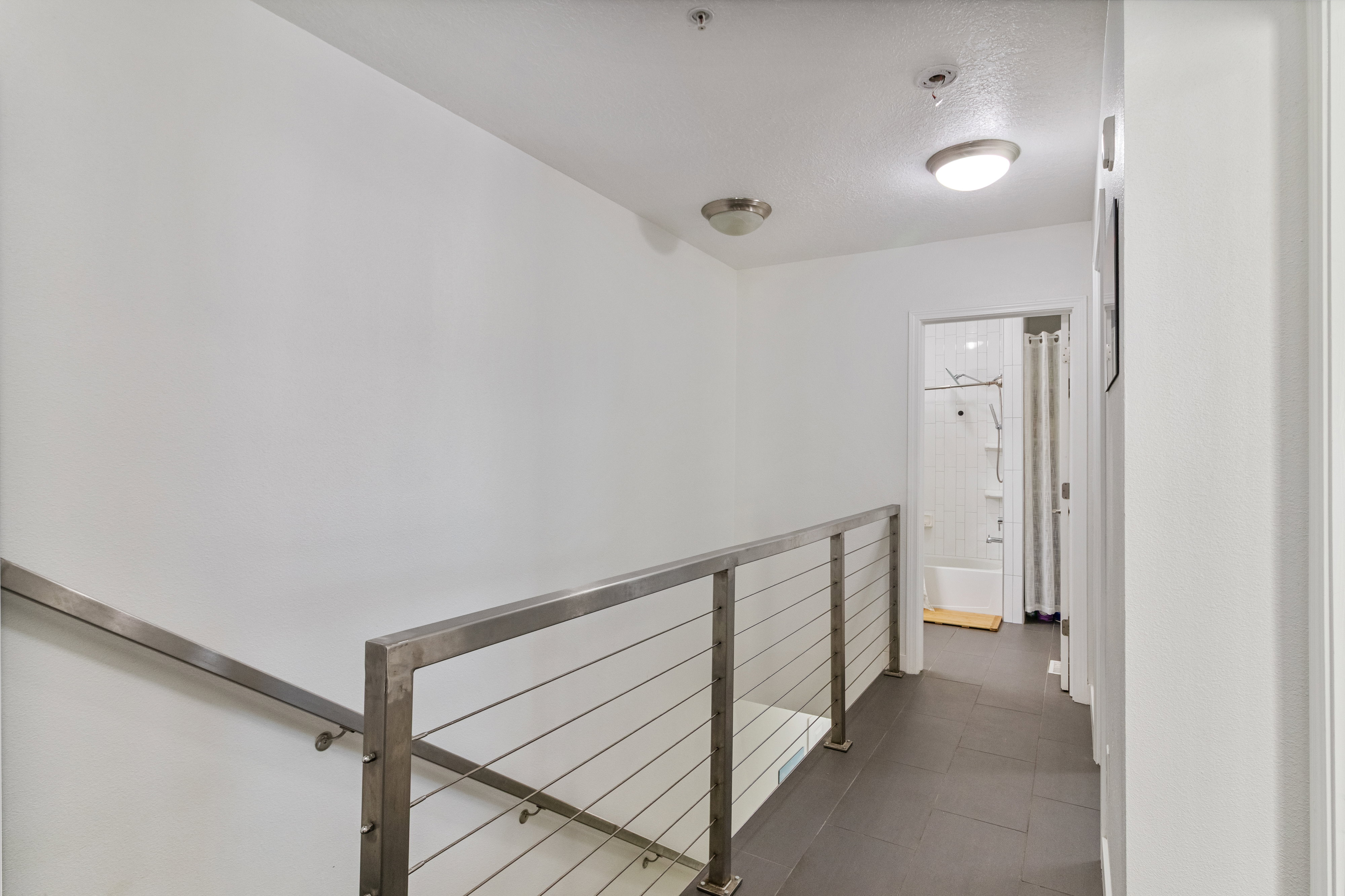 Hall featuring dark tile patterned floors.