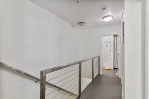 Hall featuring dark tile patterned floors.