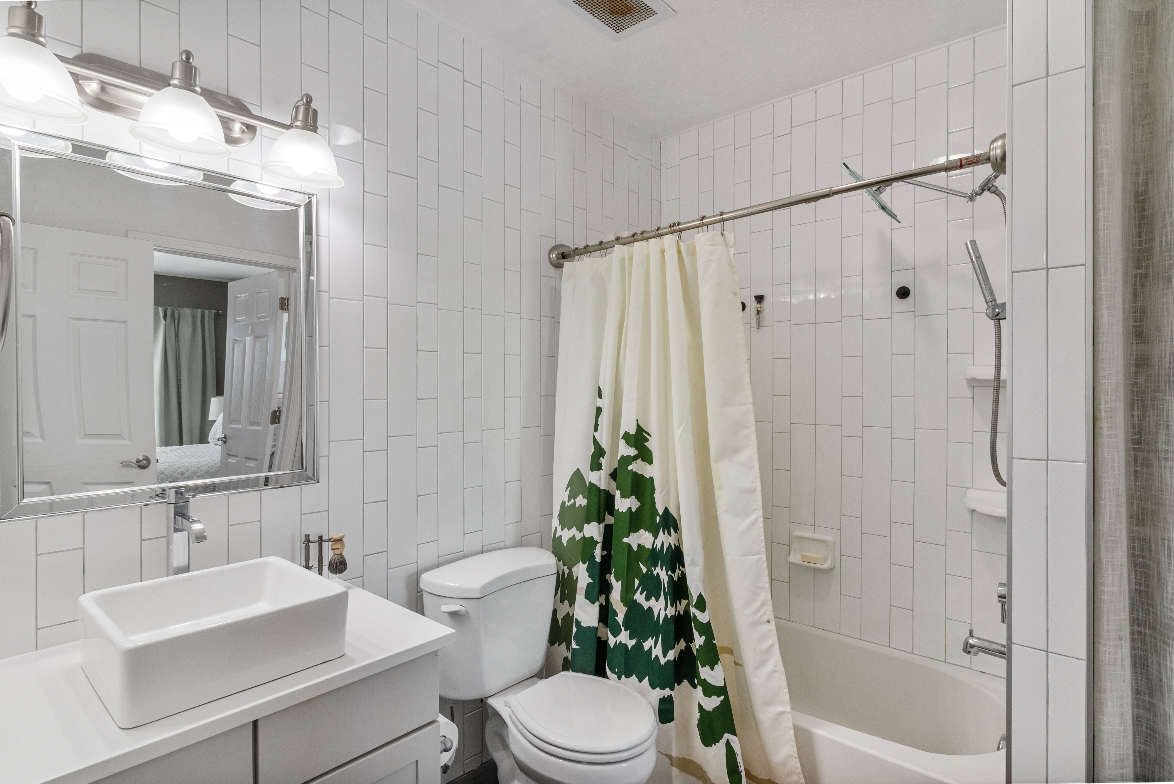 Bathroom featuring tile walls, vanity, and shower / bath combination.