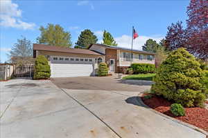 View of front of house featuring a garage, driveway, and brick siding
