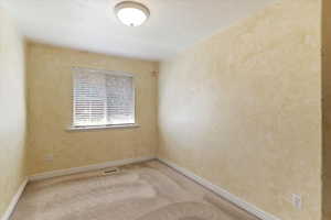 Unfurnished room featuring light colored carpet