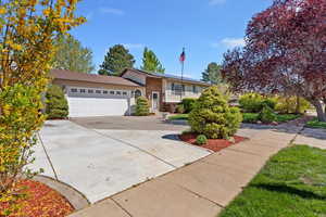 View of front of home featuring a garage, concrete driveway, and brick siding