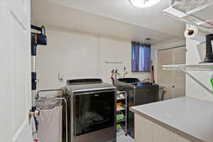 Laundry area with a textured ceiling and independent washer and dryer