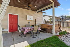 View of patio / terrace featuring a ceiling fan, outdoor dining space, and a hot tub