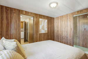 Bedroom featuring washer / dryer and wooden walls