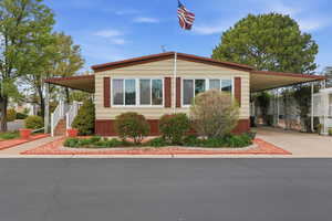 Manufactured / mobile home with a carport and concrete driveway