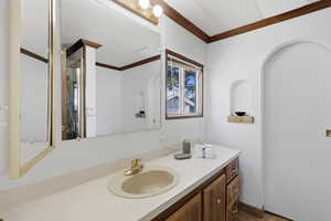 Full bathroom with ornamental molding, vanity, and a shower stall