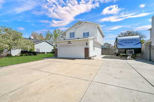 View of home's exterior featuring driveway, brick siding, a gate, and an attached garage