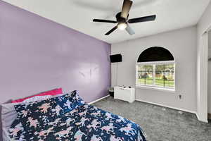 Carpeted bedroom featuring baseboards and a ceiling fan