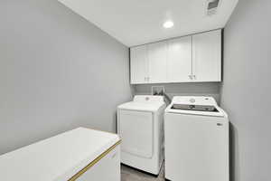 Laundry area featuring cabinet space, washer and clothes dryer, and recessed lighting