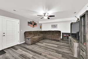 Living room with wood finished floors, a textured ceiling, and ceiling fan