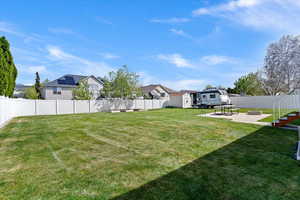 Fenced backyard featuring a patio, a residential view, and an outdoor fire pit