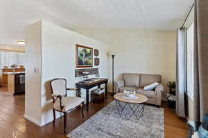 Living area featuring wood finished floors and vaulted ceiling