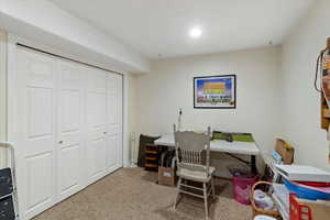 Office area featuring light colored carpet and baseboards