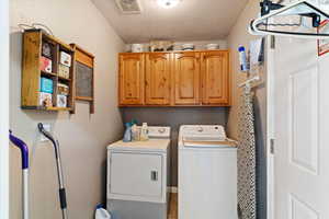 Laundry area with cabinet space and washer and clothes dryer