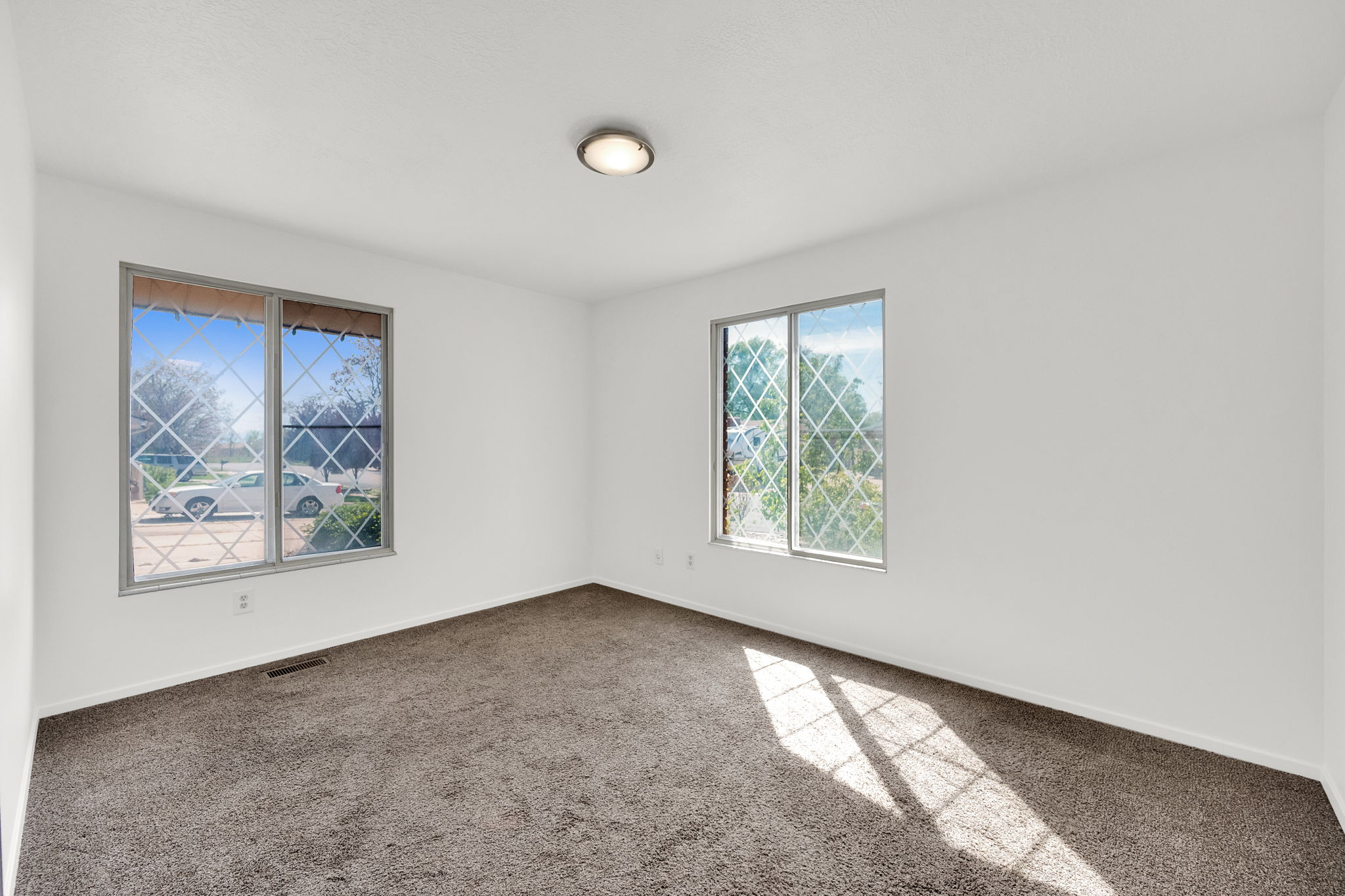 Spare room with baseboards and dark carpet